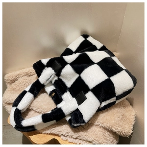 Detail of plush checkerboard laptop bag featuring soft texture and magnetic gold closure