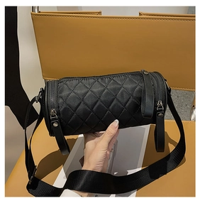 Detailed view of black quilted nylon cylinder bag featuring a textured diamond stitch pattern