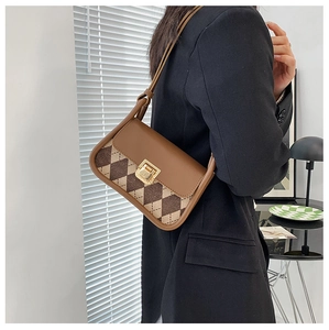 Detail of vintage plaid saddle bag with gold buckle and textured check pattern