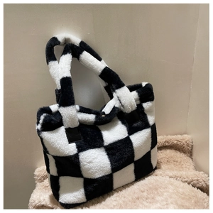 Detail of plush black and white checkered laptop tote bag with soft faux fur texture