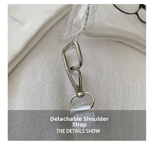 Detail showing the detachable shoulder strap with silver metal lobster clasp on a clear bag