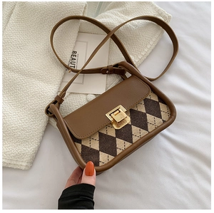 Detailed view of vintage argyle pattern fabric and gold metal lock on saddle bag