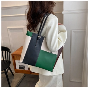 Dettaglio della grande borsa tote color-block con tracolla regolabile indossata da modella