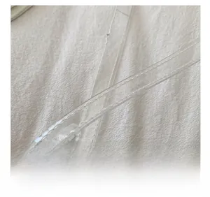 Close-up of transparent PVC shoulder strap featuring detailed white stitching on a clear band