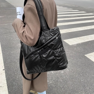 Black quilted puffer tote bag with multi-pocket design for a casual streetwear style