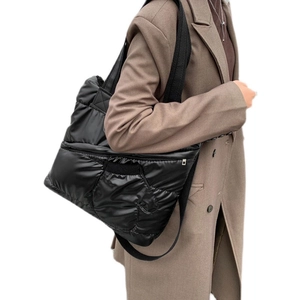 Quilted black puffer tote bag in glossy nylon with a large capacity and shoulder strap