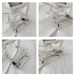 Detail view of transparent PVC saddle bag with white trim and silver metal buckle