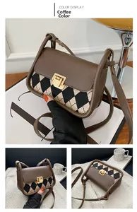 Detail view of the brown argyle pattern fabric and golden square metal clasp of the bag