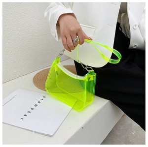 Close-up of fluorescent yellow transparent PVC underarm bag with silver metal buckle details