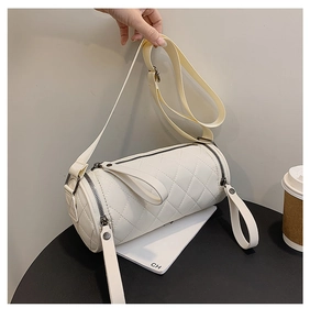 Detailed view of a white quilted cylindrical crossbody bag with zip details and strap