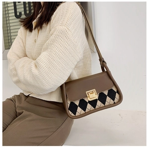 Detail view of a vintage plaid saddle bag with leather flap and golden twist lock