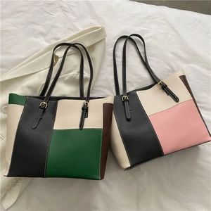 Dettaglio delle borse tote in pelle bicolore con trama martellata e fibbie dorate