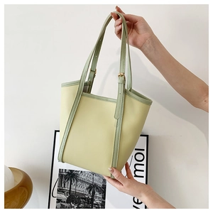 Detail of contrasting yellow and green large tote bag with adjustable PU shoulder straps