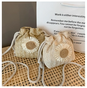 Detail of mini woven straw bags featuring 3D sunflower decor and cotton rope straps