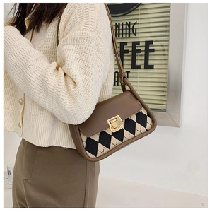Detail shot of the vintage plaid pattern fabric and brown leather flap with gold buckle