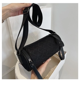 Close-up of black quilted nylon bucket bag with silver zipper and wide shoulder strap