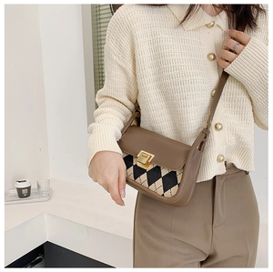 Close-up of retro plaid saddle bag with PU leather trim and gold metal buckle detail