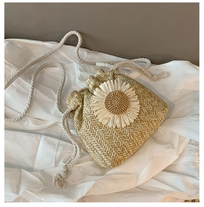Detail of straw woven bucket bag with large sunflower ornament and cotton rope strap