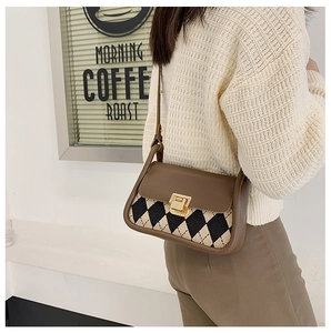 Close-up of vintage check pattern saddle bag with elegant golden clasp and leather flap