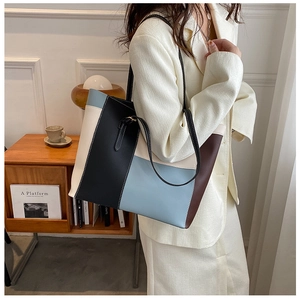 Dettaglio della borsa tote in pelle color-block con pannelli nero, azzurro e beige