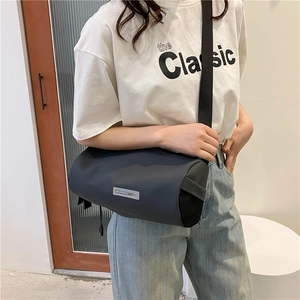 Dark grey nylon cylinder shoulder bag with side mesh pocket and adjustable strap