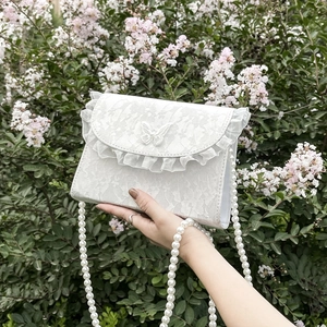 Elegant white lace crossbody bag with pearl strap and butterfly detail in nature