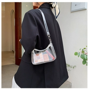 Detail view of transparent PVC crossbody bag with white trim and silver metal hardware