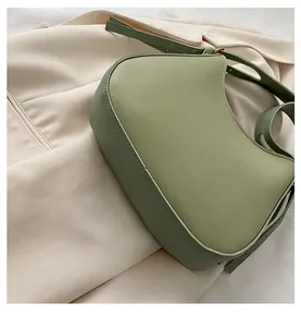 Detailed base view of avocado green half-moon crossbody bag with neat stitching
