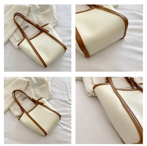 Detailed view of cream tote bag with brown leather trim and adjustable shoulder strap