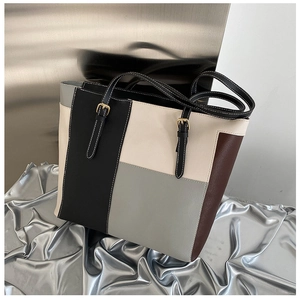 Dettaglio della borsa tote in pelle color-block con cuciture a contrasto e fibbia oro