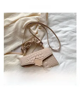 Détail du sac à main en cuir beige avec boucle dorée et poignée à effet froncé chic