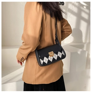 Detail of vintage argyle saddle bag with gold metal buckle shown on a model's shoulder