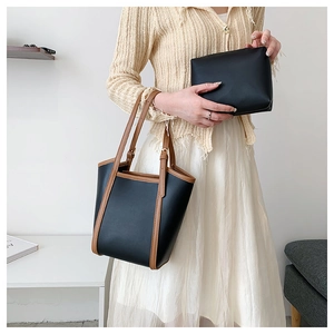 Minimalist black tote bag with brown trim detail and a matching pouch for women