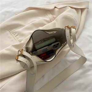Interior view of cream leather shoulder bag showing capacity for phone and cosmetics