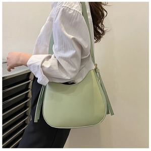 Detail of mint green half-moon underarm bag with adjustable strap and gold hardware