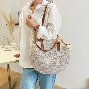 Minimalist straw tote bag with brown leather handles and woven wave texture pattern
