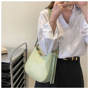 Detail of mint green hobo shoulder bag with adjustable strap and gold metal buckle