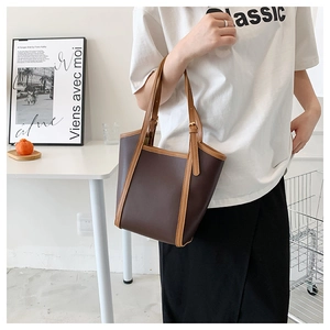 Detail of the large two-tone tote bag in dark brown faux leather with khaki straps