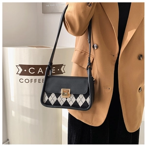 Detail of vintage plaid saddle bag with gold buckle on camel blazer outfit