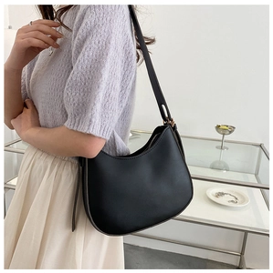 Minimalist black matte leather underarm bag shown with a stylish semi-moon curved design