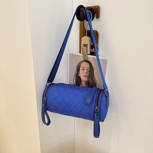 Quilted blue nylon cylinder crossbody bag with adjustable strap and sporty design