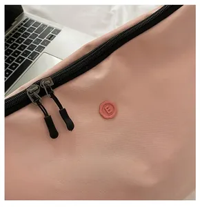 Détail de la fermeture éclair double et du texte sur le sac en nylon rose de qualité