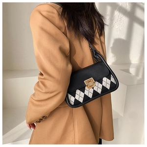 Detail of vintage plaid saddle bag with premium gold rotary buckle and leather finish