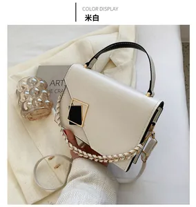 Detailed view of creamy white handbag with gold buckle and woven leather chain strap