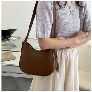 Close-up of brown matte leather Hobo bag with tassel zipper and adjustable wide strap