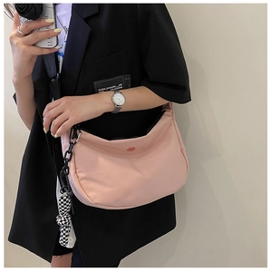 Détail du sac demi-lune rose avec chaîne noire et breloque oreilles de lapin