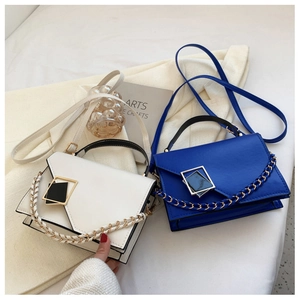 Detail of a chic shoulder bag with a gold geometric clasp and woven chain strap