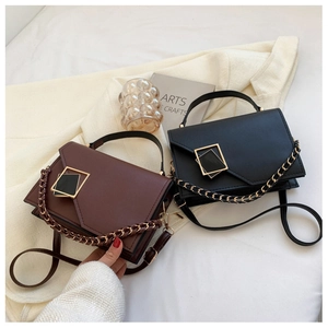 Close-up of stylish leather handbags with geometric metal buckles and chain straps