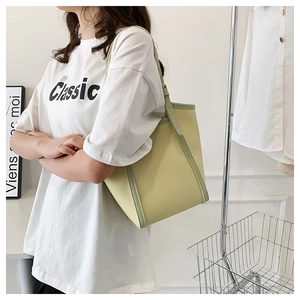 Side view of large light green tote bag with contrast edge detailing for office wear
