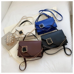 Flat lay of multiple cross-body flap bags in white, blue, black, and brown with gold buckles